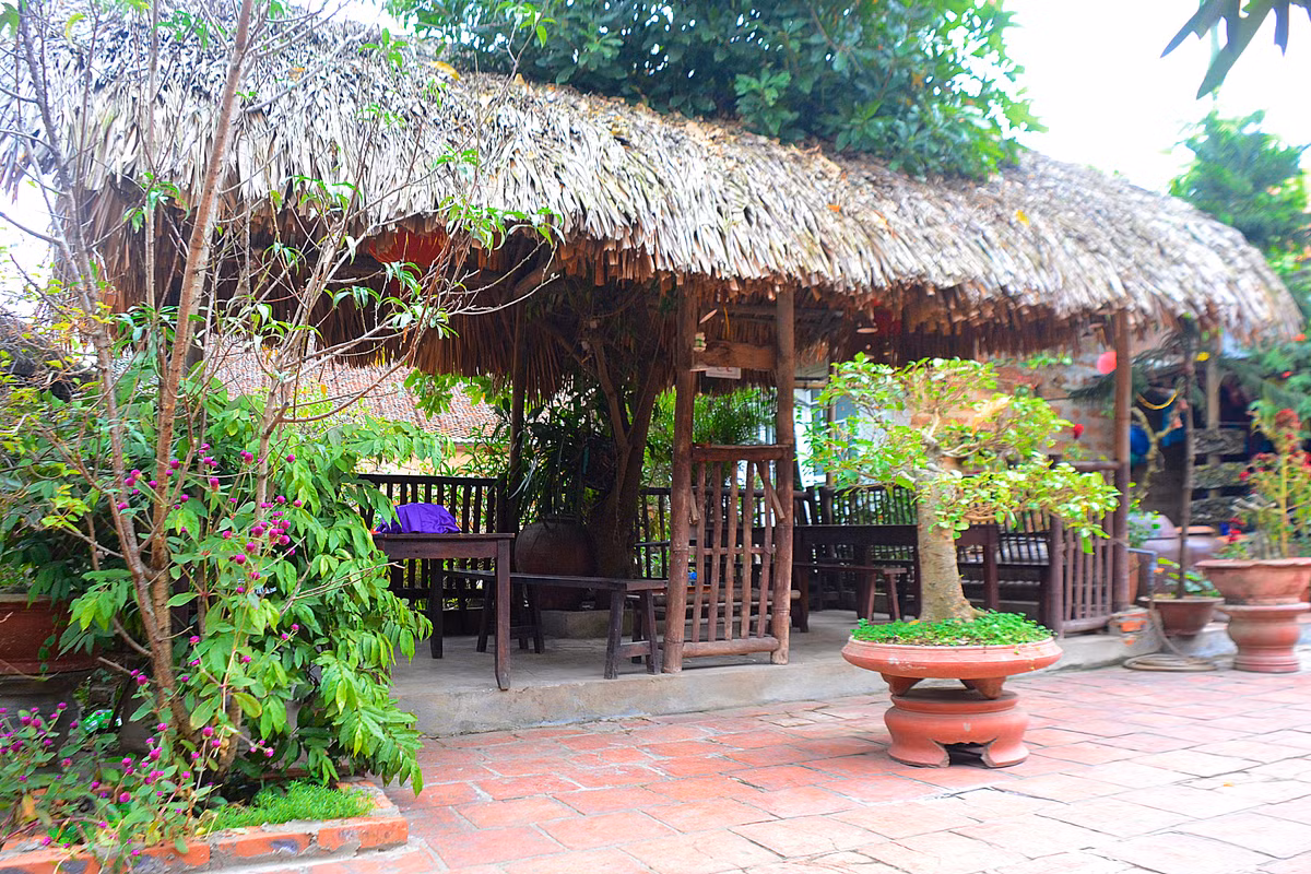 Trong gian nhà mái lá có hai bộ bàn ghế...