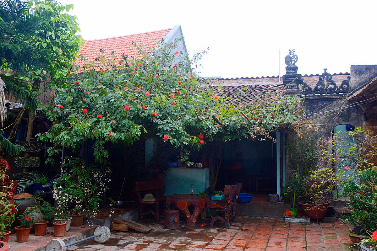 Trước hiên bếp là giàn hoa, vừa tạo màu sắc sống động vừa làm cho ngôi nhà mang phong cách thôn quê dân dã.