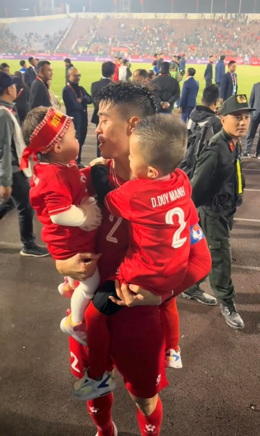 Đến sân Việt Trì để cổ vũ cho bố, hai em bé được mẹ diện áo đấu của tuyển Việt Nam, đằng sau là số áo và tên của Duy Mạnh.