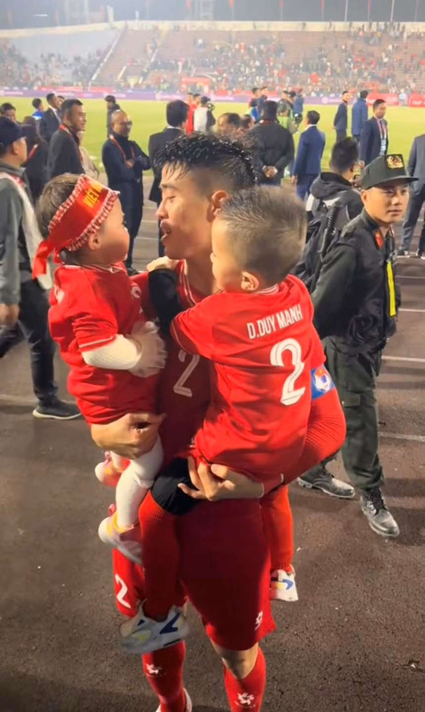 Đến sân Việt Trì để cổ vũ cho bố, hai em bé được mẹ diện áo đấu của tuyển Việt Nam, đằng sau là số áo và tên của Duy Mạnh.