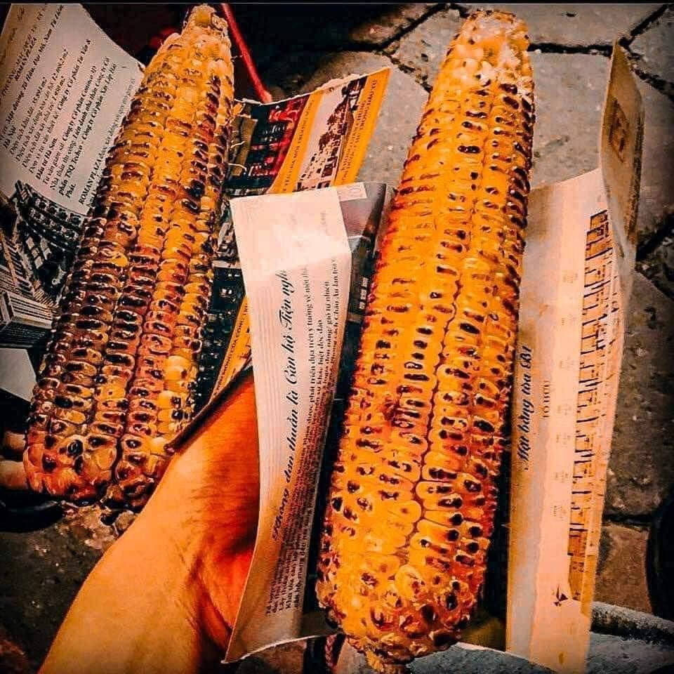 Hà Nội mùa đông, ngõ ngách nào cũng rực lửa. Những bếp than hồng bập bùng, tỏa ra mùi thơm nồng nàn của ngô khoai nướng, vẽ nên một bức tranh đường phố ấm áp. Dọc các tuyến phố Tây Sơn, Tôn Thất Tùng, Nguyễn Lương Bằng, hình ảnh những gánh hàng rong giản dị với ngô khoai nướng nghi ngút khói trở nên quen thuộc.