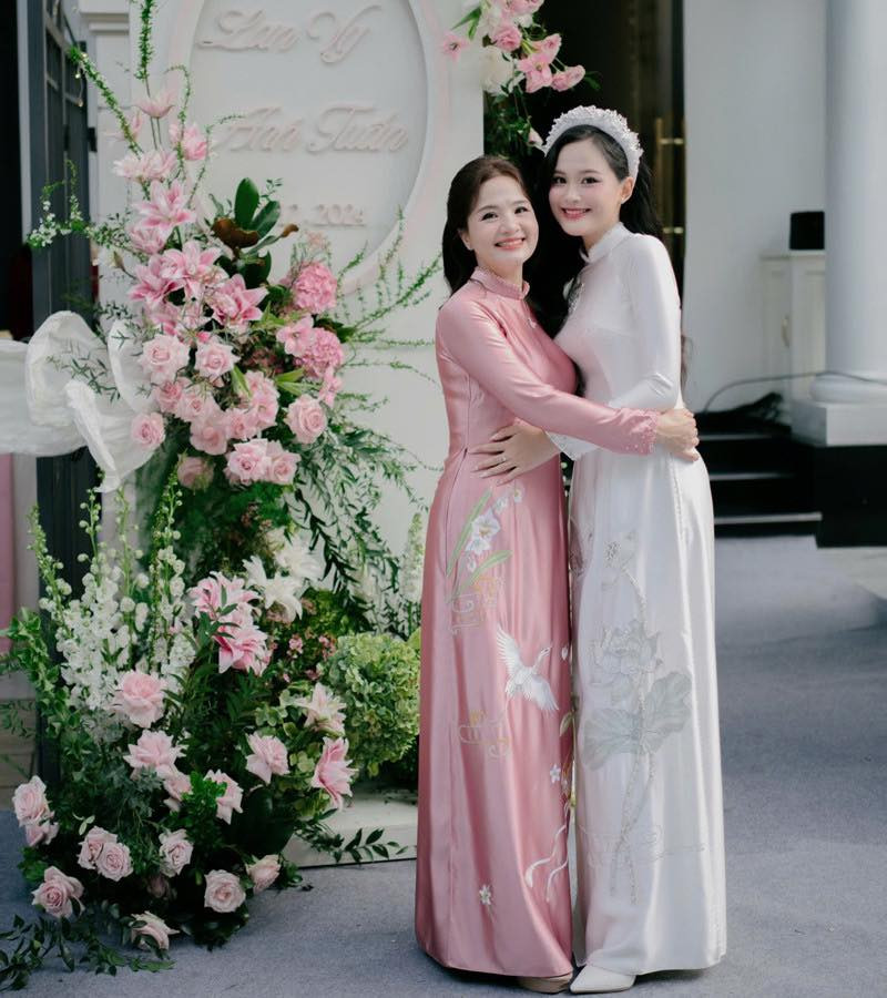 Đứng chung khung hình với con gái, bà mẹ tỏa sáng với nụ cười rạng rỡ.