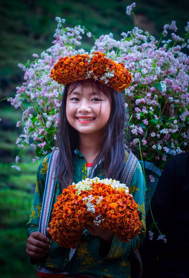 Cô bé gây sốt với hình ảnh đeo gùi hoa đứng ở dốc Thẩm Mã (Hà Giang) với gương mặt xinh xắn và nụ cười rạng ngời.