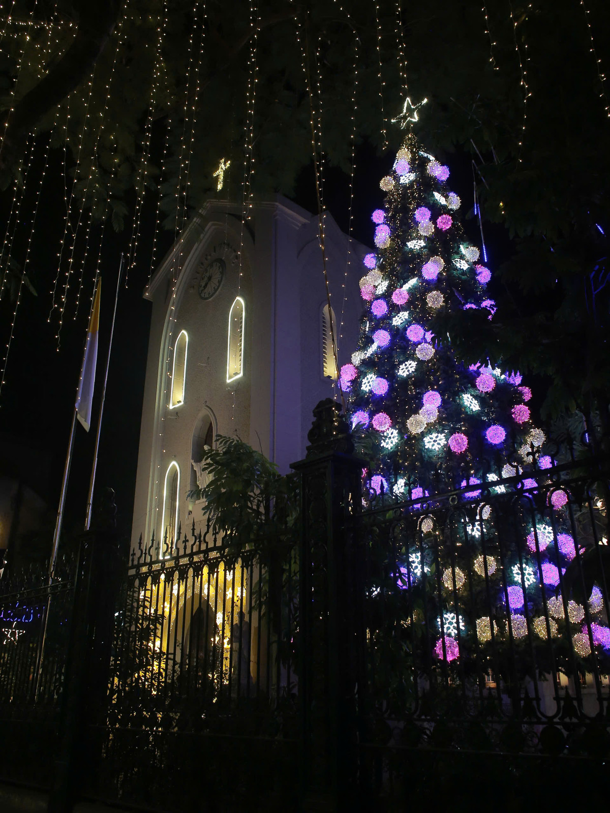 Nhìn từ bên ngoài, nhà thờ hiện lên lung linh với cây thông khổng lồ nổi bật ở phía trước, được trang trí bởi hàng trăm quả cầu ánh sáng đủ màu sắc.