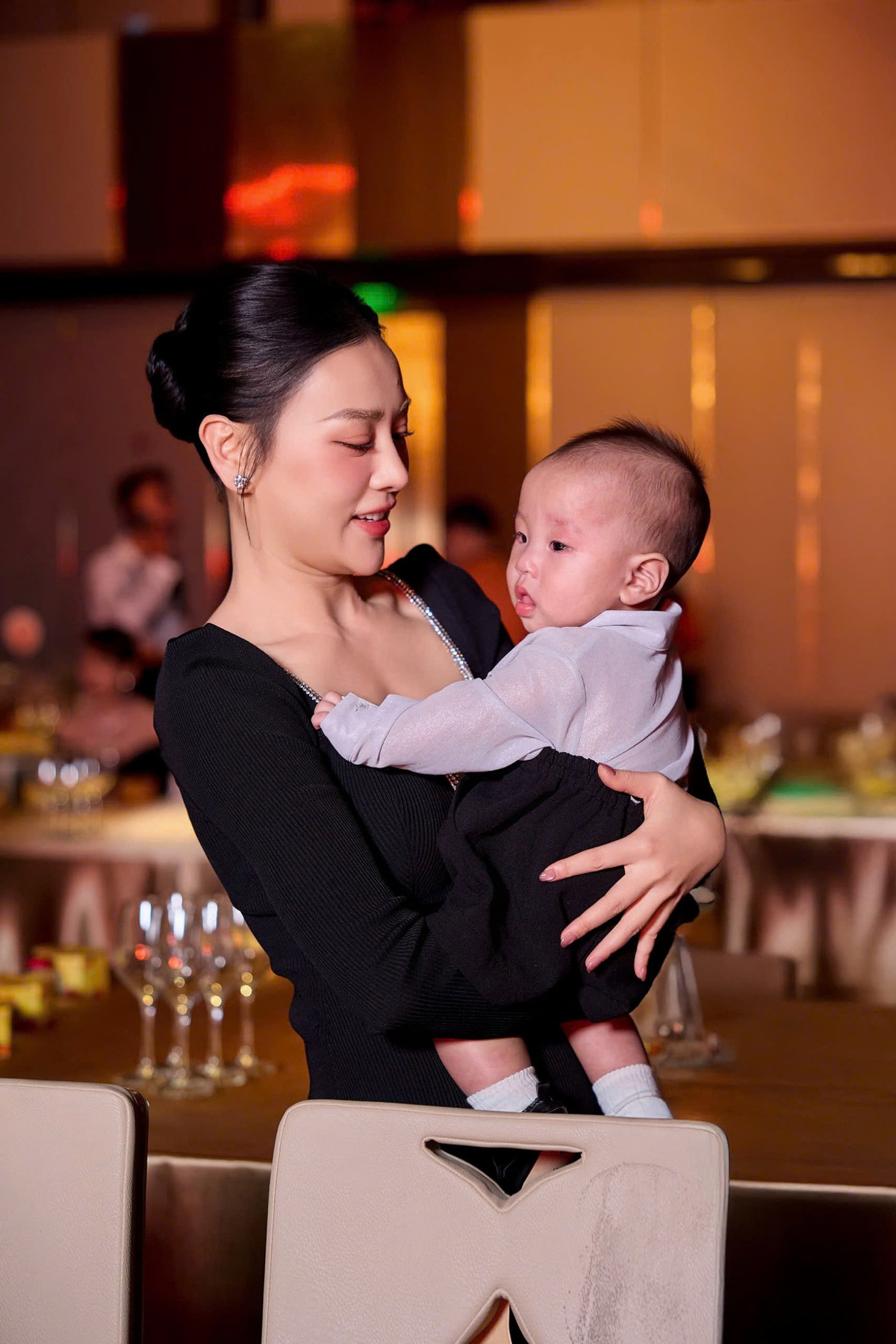 Phương Oanh cùng Shark Bình thay nhau cho cặp song sinh uống sữa, dỗ dành em bé.