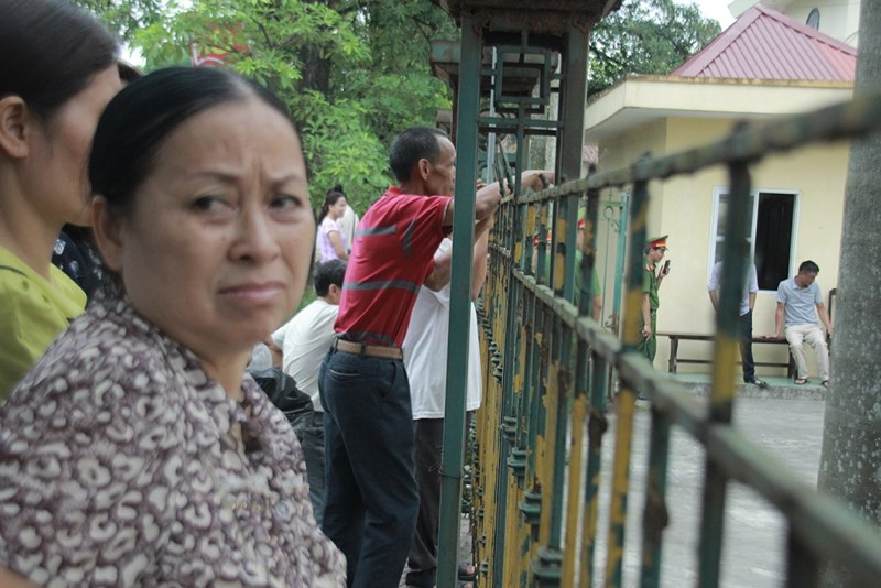 Nhiều người đứng từ phía ngoài để ngóng vào trong, theo dõi diễn biến phiên tòa.