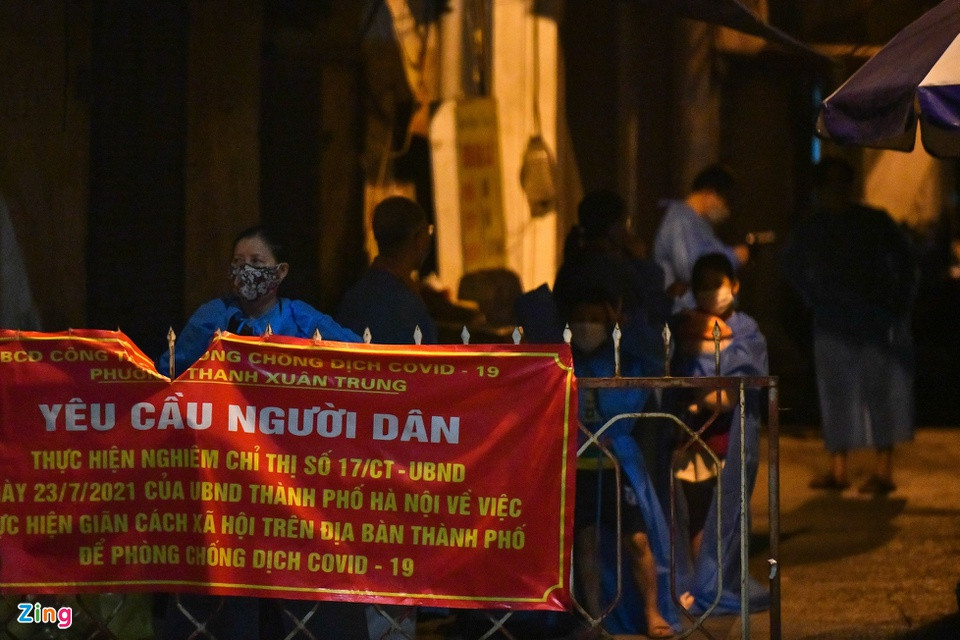 Người dân ngồi chờ nhân viên y tế làm công tác khử khuẩn, chuẩn bị. Trong khoảng 2 giờ, khoảng 15 người được đi cách ly tập trung. 