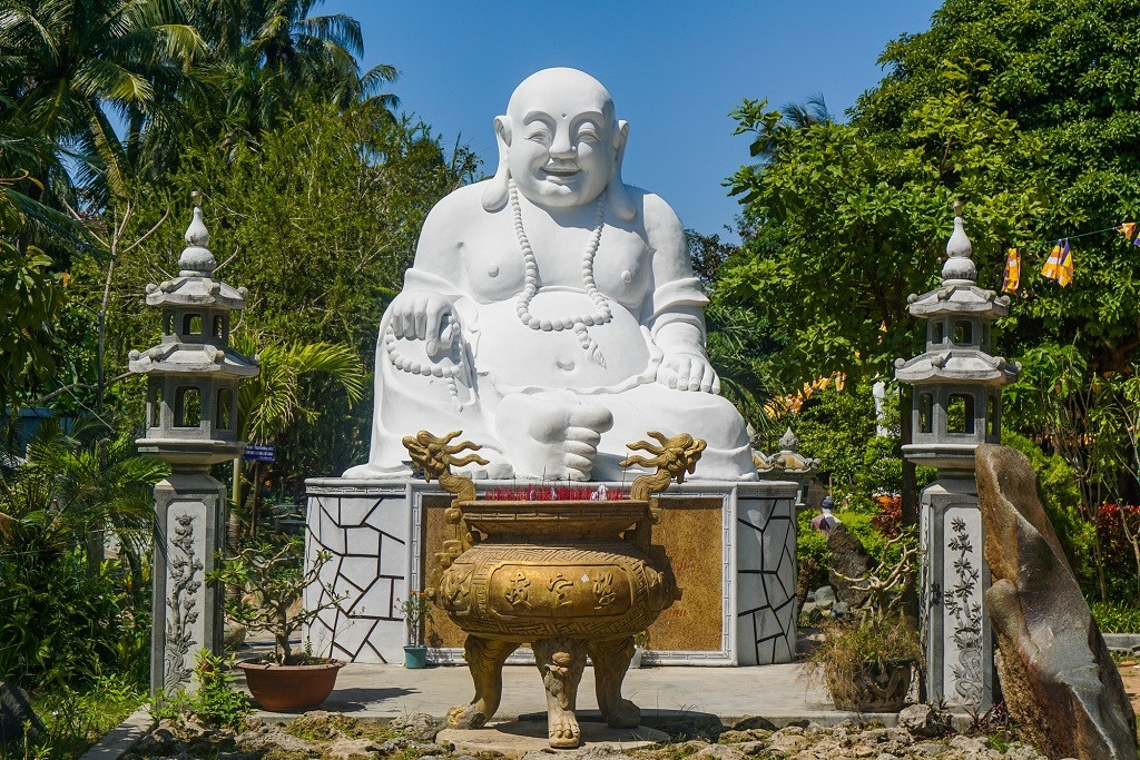 Đi qua cổng chùa, ta sẽ bắt gặp ngay trước mắt bức tượng đức Phật Di Lặc với nụ cười an nhiên tự tại của một người như đã hiểu hết lẽ đời. Kế đến là không gian của đá, những hòn đá được đặt cạnh nhau tạo nên một thế giới riêng. Bên trái ngôi chùa, sen đang ngát hương như tô điểm cho bức tranh thêm sức sống. Mái tam quan được giữ nguyên vẻ cổ kính với mái ngói nâu đỏ rêu phong. Toàn bộ cảnh chùa như ẩn hiện dưới tán cây cổ thụ, tạo cho ta một cảm giác yên bình.