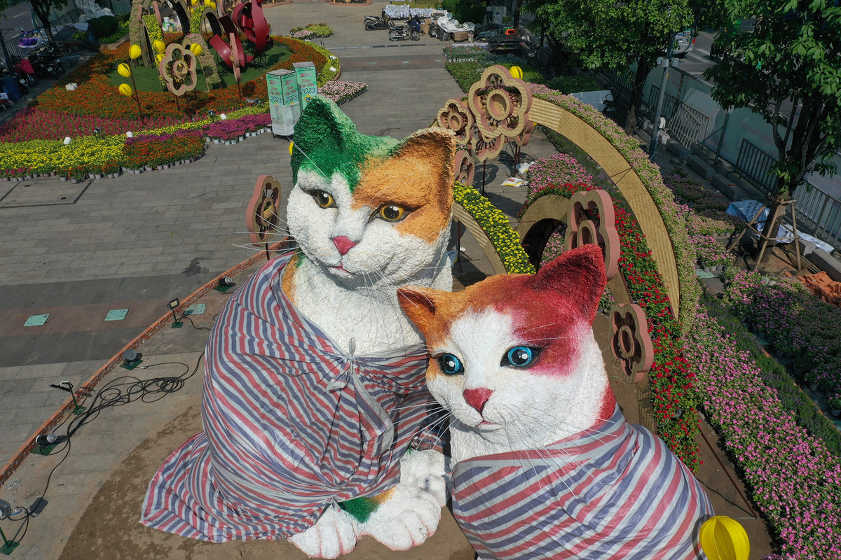 Cổng kết là đôi linh vật mèo cao nhất đường hoa lần lượt là 4,5 cà 5,5m, thân được kết từ hơn 400m vải, thi công trong 3 tuần với nhiều công đoạn từ tạo hình linh vật với mút xốp, phủ vải mùng và cao su non, thêm lớp vải xô bồi keo, lại phủ thêm bông gai nhuyễn, kế đến mới xếp vải và phủ lớp chống thấm. (Ảnh: Người đưa tin)