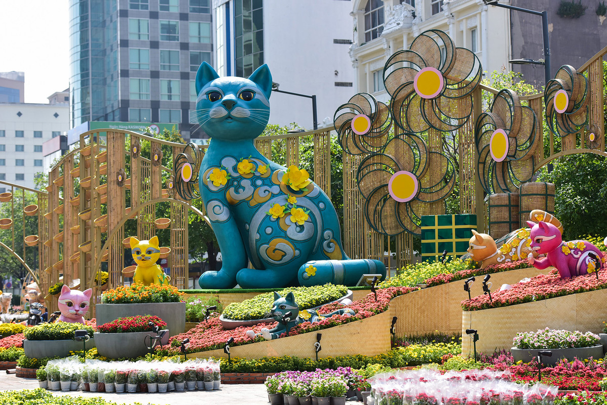 Sau nhiều ngày thi công đường hoa Nguyễn Huệ Tết Quý Mão 2023 với chủ đề “Thành phố Hồ Chí Minh - Xuân an vui, xuân thịnh vượng” cơ bản đã hoàn thành những hạng mục chính. Đại cảnh cổng chào đường hoa có 6 linh vật mèo cao từ 0,8-4,5m, được tạo hình bằng xốp, sơn mỹ thuật giả gốm đã lắp đặt xong. Phông nền đại cảnh phía sau đảo lớn được phân thành lớp trải dài từ phải sang trái với hơn 90 giỏ hoa được sử dụng trên vách tre cao 5,9 m và rộng 46,3 m, xen kẽ với những bông hoa lớn được tạo hình bởi khung sắt, ốp lưới mây mắt cáo làm cánh hoa. (Ảnh: Người đưa tin)