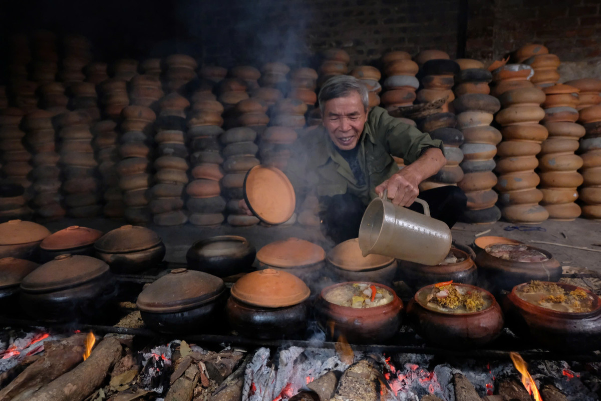 Để có nồi cá kho ngon, công đoạn canh lửa, tiếp nước cũng rất quan trọng. Nước tiếp vào nồi cá đang kho ngon nhất là nước xương hầm. Phải tiếp nước nóng, không được tiếp nước nguội, cá tanh, mất độ béo, không chắc thịt. (Ảnh: Tuyết Vân)