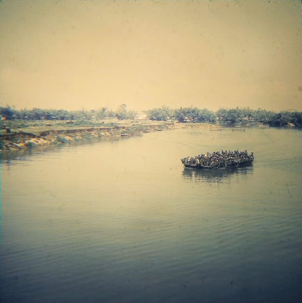 Lính Mỹ chen chúc trên một chiếc xuồng chở quân giữa dòng sông.