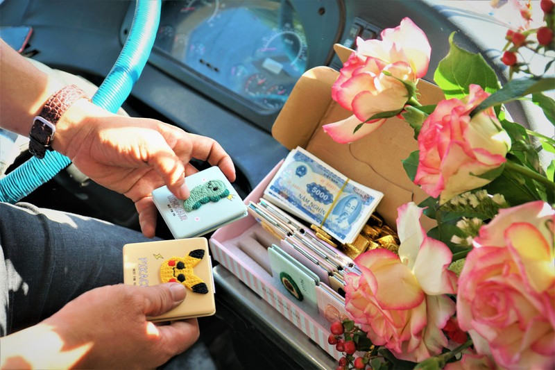 Dừng đèn đỏ, anh Huy nhanh tay sắp xếp lại các món quà.