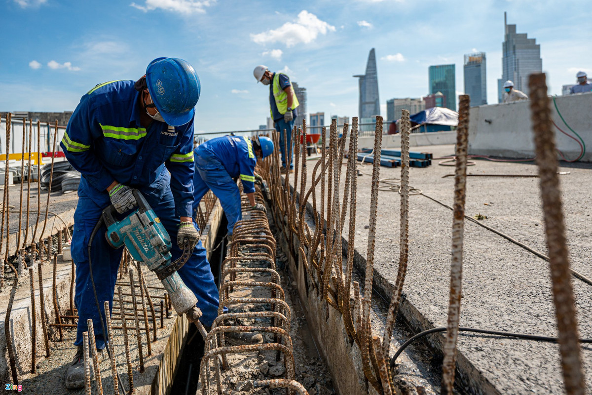 Công nhân đang khoan đục để tạo vị trí lấp đặt khe co giãn. Khe đồng thời được cấu tạo để chống ồn khi phương tiện lưu thông qua cầu.