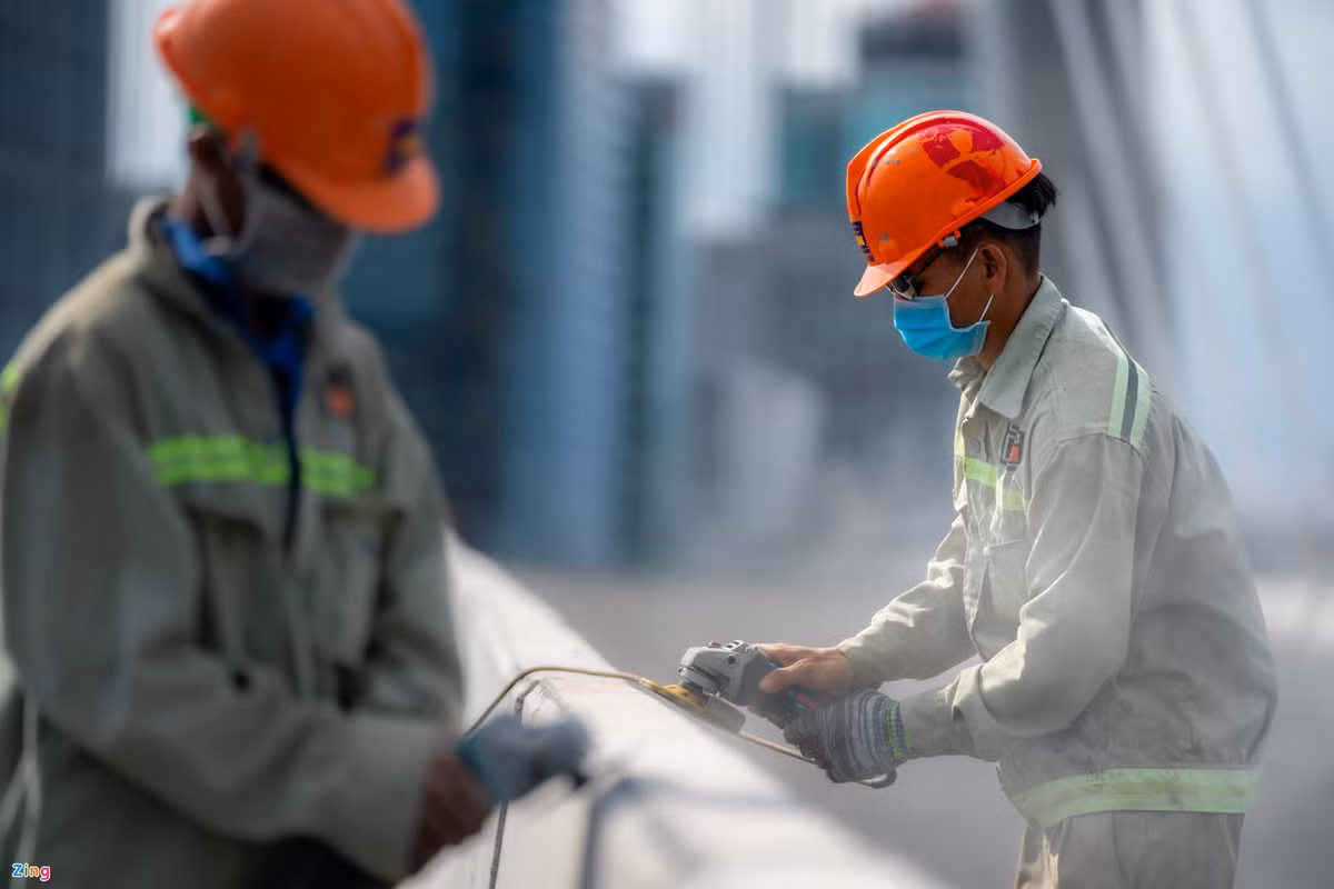 Anh Phùng Đức Quang (33 tuổi, công nhân) cho biết đã làm việc tại công trình gần 3 năm. "Trong 2 năm dịch bệnh kéo dài nhưng tôi vẫn được làm việc và có tiền trang trải cuộc sống. Trước đó công trình bị gián đoạn không ít lần vì chưa có mặt bằng thi công, nhưng khó khăn cũng được giải quyết nhanh nên công trường thi công trở lại và hoàn thành như bây giờ", nam công nhân nói khi đang mài nhẵn dải phân cách của cầu.