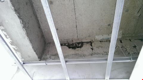 Một mảng tường xi măng bị bong tróc, lộ cốt thép ra ngoài tại dự án The Easter City.