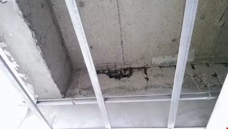 Một mảng tường xi măng bị bong tróc, lộ cốt thép ra ngoài tại dự án The Easter City.