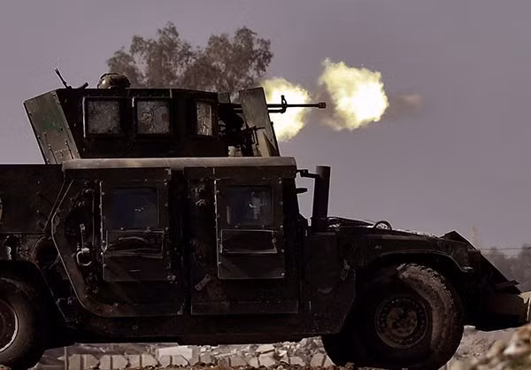 Quân đội Iraq đang nã đại liên về phía vị trí của nhóm khủng bố IS trong lần giành giật nhau tuyến đường trọng yếu. Ảnh FNA