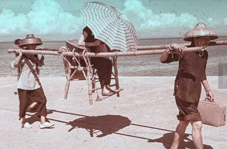 Hai người khiêng kiệu trên con đường nắng gắt năm 1960. Ảnh xilu