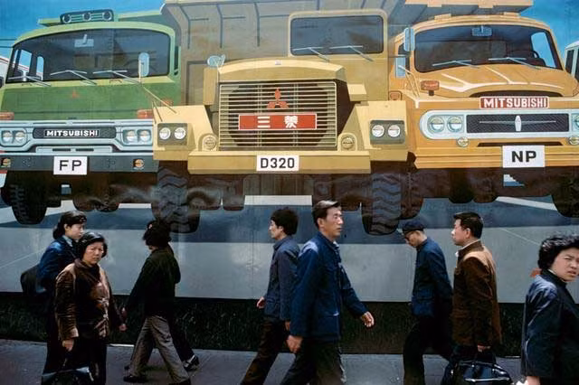 Người dân đi ngang qua chỗ quảng cáo xe hơi Nhật Bản ở Thượng Hải. Ảnh Sina