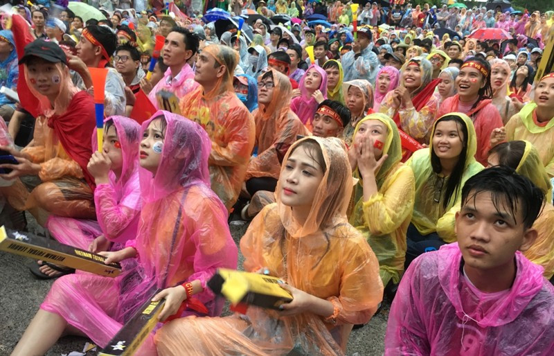 Thế nhưng hàng nghìn người vẫn bất chấp mưa, ngồi ngay vị trí của mình để cổ vũ nồng nhiệt đội bóng "con cưng" của Việt Nam.