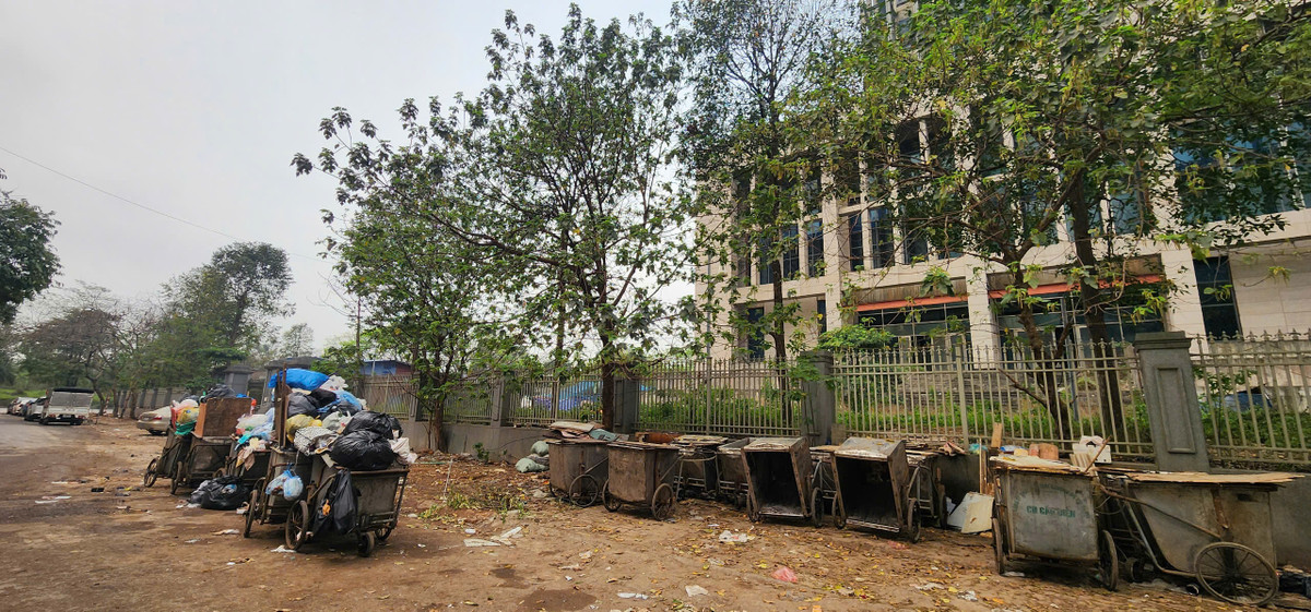 Ngay sát tường trụ sở là điểm tập kết rác với mùi hôi thối bốc lên.
