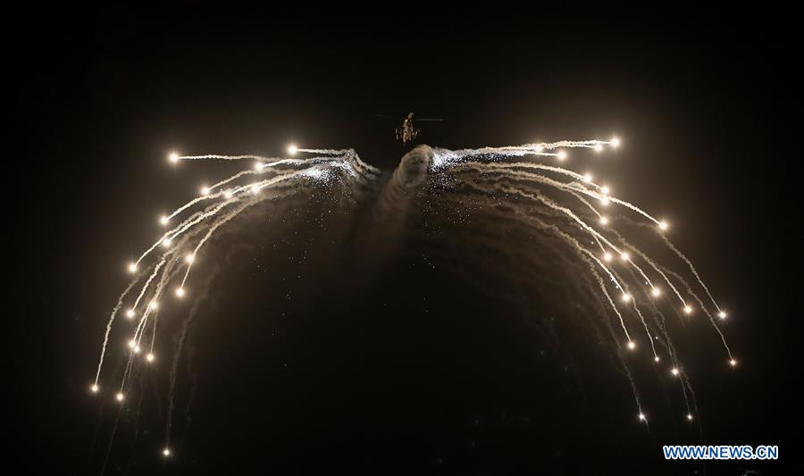 Trực thăng tấn công Apache sử dụng pháo mồi nhiệt trong màn trình diễn bay đêm cực kỳ mãn nhãn. Nguồn ảnh: Xinhua.