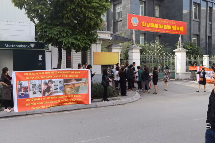 Ngay từ sáng sớm rất đông người dân tập trung ngay trước cổng Toà án nhân dân TP Hà Nội. Nhiều người cũng cầm băng rôn với mong muốn toà nghiêm trị hành vi mà Tuấn và Lan Anh đã gây ra. Từ sáng sớm, bà Vũ Thị Dự (51 tuổi, ở Đông Anh, Hà Nội, bà ngoại cháu bé) đã có mặt tại toà án, chờ đợi phiên xét xử. Bà Dự mang theo di ảnh, quần áo, gấu bông, bình sữa của cháu M. đến phiên toà.