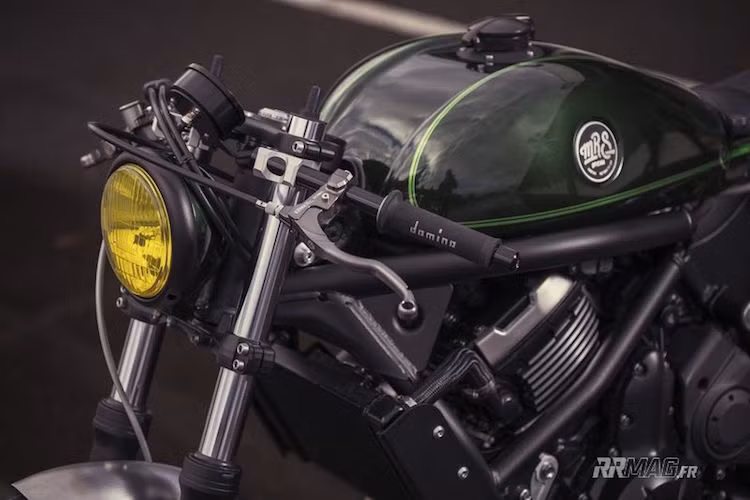 Dù giữ nguyên cặp phuộc trước nguyên bản nhưng tay lái dạng cruiser gốc của Vulcan S đã được thay bằng cặp tay clip-on "chuẩn bài" cafe racer, kèm theo đèn pha "gáo dừa" đơn giản và cặp tay nắm Domino.