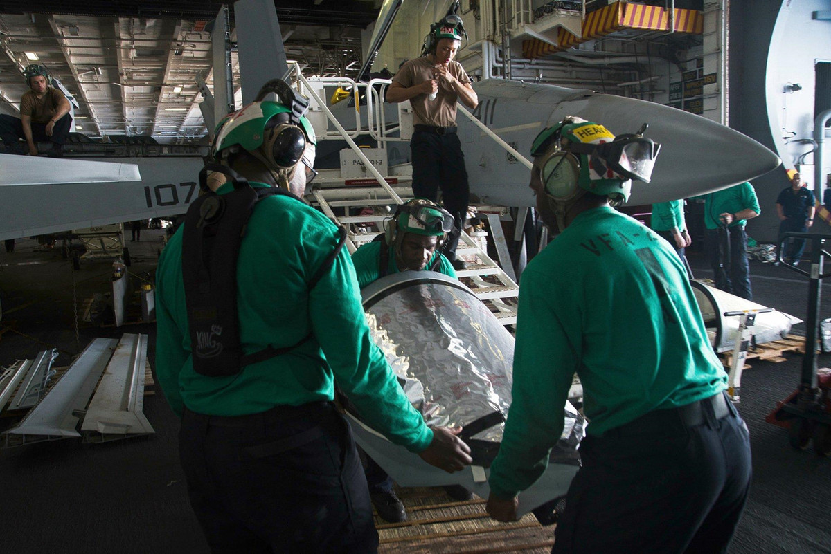 Các kỹ thuật viên đang bảo trì tiêm kích F/A-18 bên trong nhà chứa máy bay. Những ngày gần đây, chính quyền Tổng thống Trump nhấn mạnh muốn nói chuyện với Iran mà không đưa ra điều kiện tiên quyết nào. Ảnh: AP