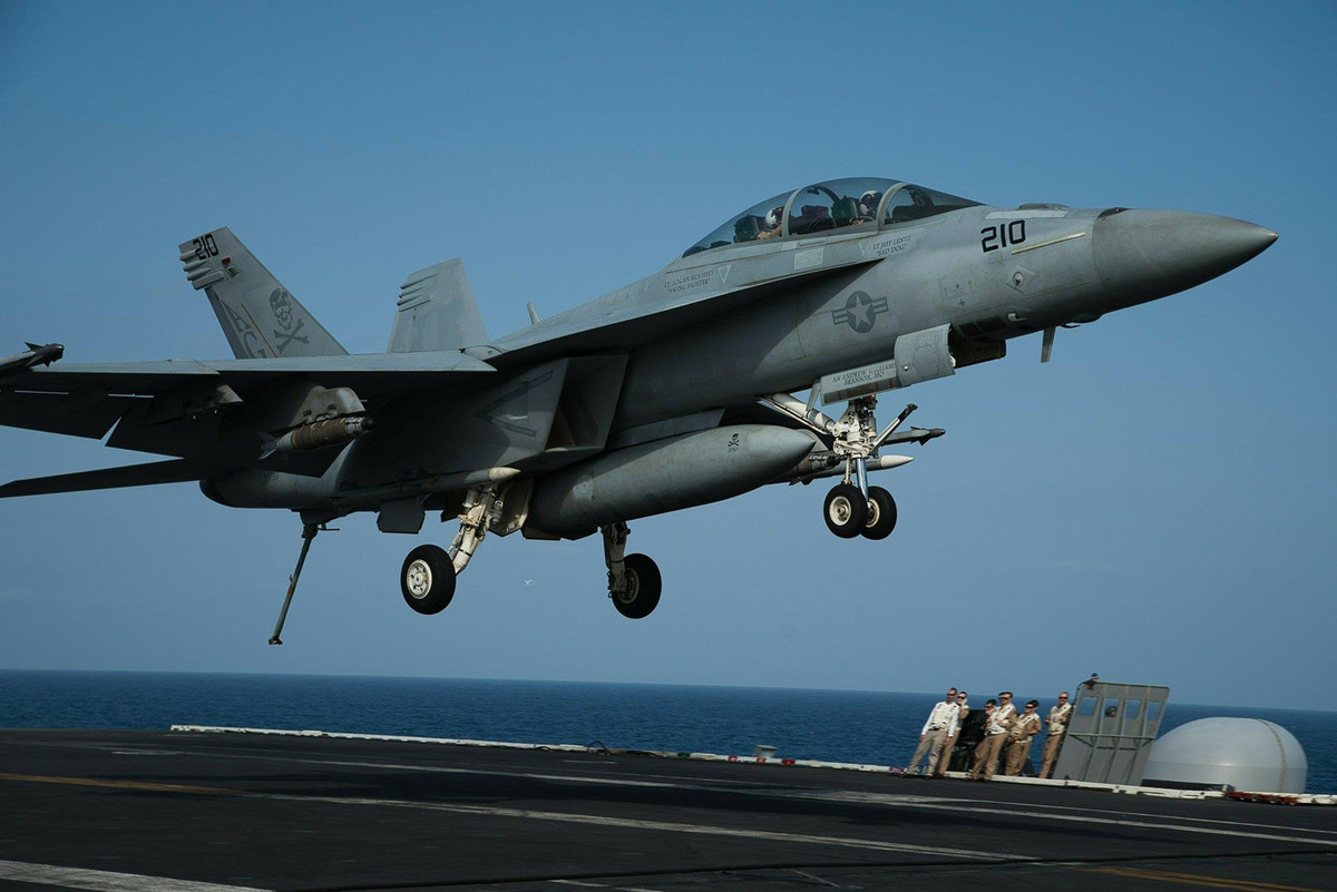 Căng thẳng giữa Mỹ và Iran bùng phát sau khi Tổng thống Donald Trump gọi Vệ binh Cách mạng Iran là tổ chức khủng bố. Trong ảnh, tiêm kích trên hạm F/A-18F Super Hornet chuẩn bị hạ cánh trước sự quan sát của các nhà báo được mời lên tàu. Ảnh: AP