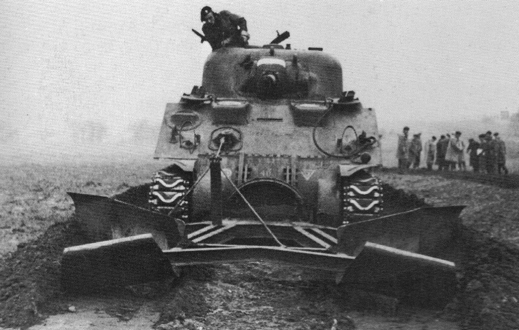 Normandie hoàn toàn không có hệ thống giao thông ở bãi biển, và thực tế là trên thế giới này ít nơi có đường giao thông chạy ra tận mép nước cả. Tuy nhiên quân Đồng minh lại cần các tuyến giao thông này để tải hàng tiếp tế, kết quả là các loại phương tiện thiết giáp làm đường đã được ra đời để sử dụng tại đây. Nguồn ảnh: IWM.