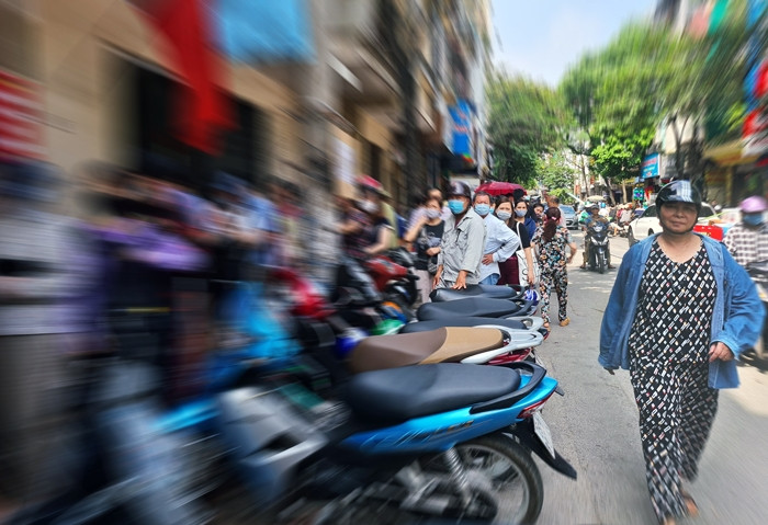 Thời tiết càng càng về trưa càng trở nên nắng nóng, oi bức nhưng nhiều người vẫn kiên nhẫn xếp hàng chờ mua bánh bằng được.