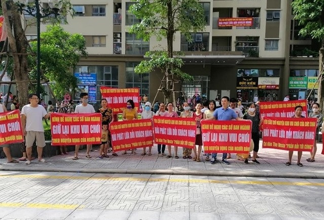 Nhiều băng rôn, khẩu hiệu đỏ rực được người dân mang xuống sân để phản đối chủ đầu tư.