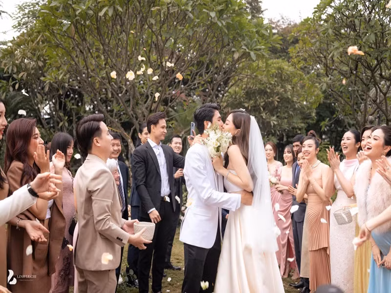 Cô dâu chú rể hôn nhau đắm đuối trước sự hò reo của bạn bè, người thân. Ảnh: Linh Lê Chí