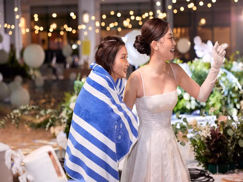 Khả Ngân được cô dâu chú rể cung cấp khăn khô để lau người. Ảnh: FB Khả Ngân