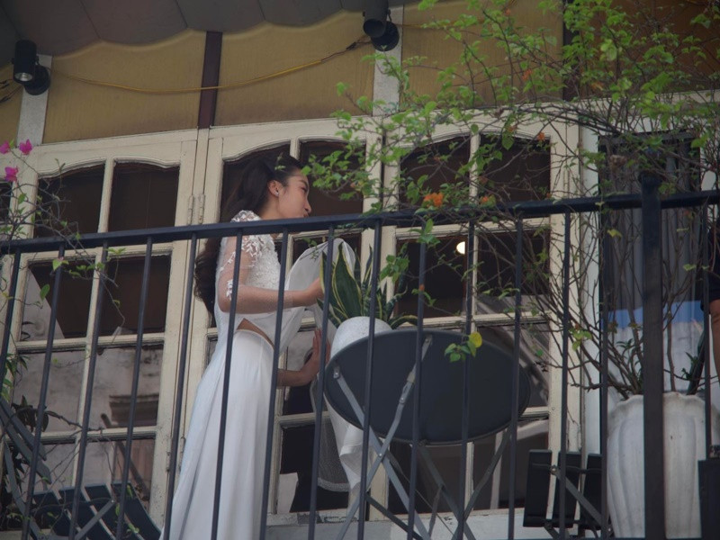 Đỗ Mỹ Linh diện áo dài trắng, xuất hiện bên ngoài hiên nhà. Ảnh: Thể thao văn hóa