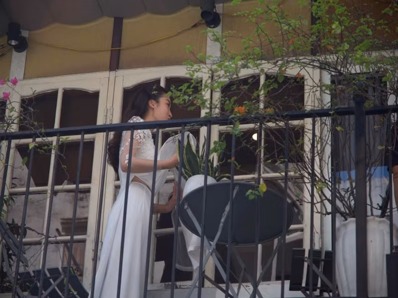 Đỗ Mỹ Linh diện áo dài trắng, xuất hiện bên ngoài hiên nhà. Ảnh: Thể thao văn hóa