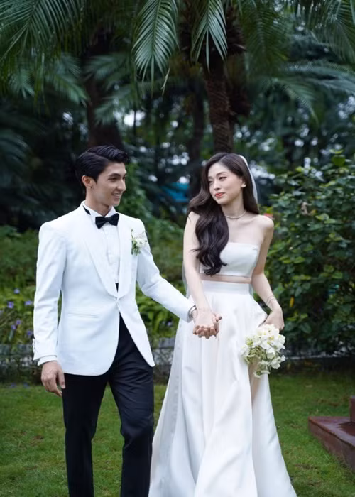 Bình An nắm tay Phương Nga không rời trong đám cưới. Đôi uyên ương trao lời thề nguyện. Vietnamnet dẫn lời chú rể: "Chào bạn, người đã luôn đồng hành cùng mình suốt 4 năm 9 tháng 3 tuần vừa qua. Mình là người không bao giờ tin vào chuyện cổ tích và bạn cũng không. Nhưng bạn có thấy câu chuyện của chúng mình thật lạ? Nó sẽ chẳng giống một bộ phim nào cả. Ngay từ những ngày bắt đầu, từ lần đầu tiên chúng ta gặp nhau. Hai đứa không hề có một người bạn chung mà chỉ là sự tình cờ. Sau khi tìm hiểu về nhau, chúng ta đều thấy 2 đứa không hề có một sở thích nào chung. Mình là người sến sẩm còn bạn có đôi chút nhạt nhòa". Ảnh: Yan