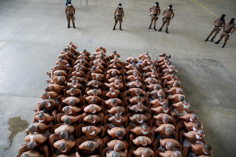 Các bức ảnh cho thấy, những thành viên của băng đảng MS-13 và 18, hầu hết đều đeo khẩu trang phòng COVID-19, ngồi sát nhau khi giới chức trách đi kiểm tra nhà tù. 