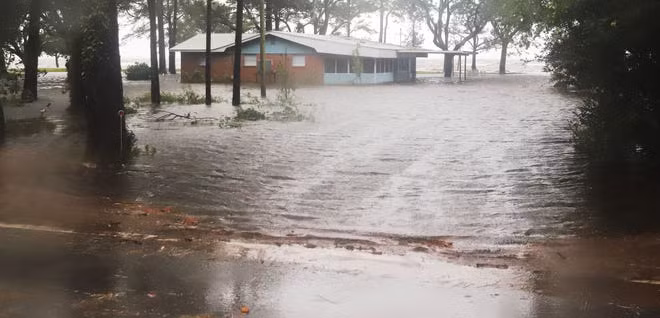 Nước lũ bao vây một ngôi nhà ở Basin Bayou. Ảnh: NWFDaily News.