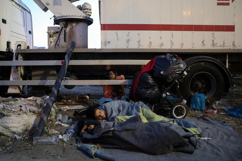 Chưa có chỗ ở mới, người di cư này phải nằm ngủ ngoài trời, cạnh một chiếc xe tải.