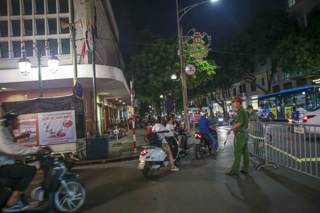 Lực lượng công an đang điều hướng các phương tiện giao thông ra khỏi khu vực phố đi bộ. Ảnh: Tuấn Đức - TTXVN