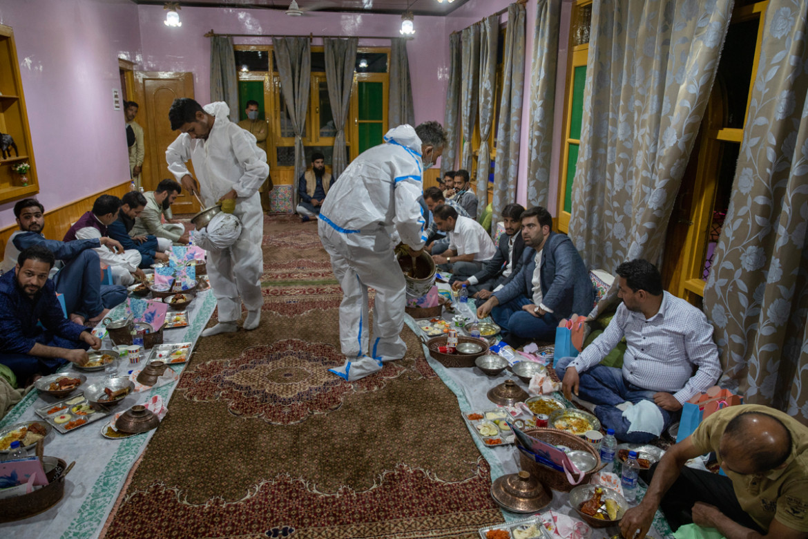 Đầu bếp mặc đồ bảo hộ mang thức ăn đến cho các vị khách trong đám cưới.