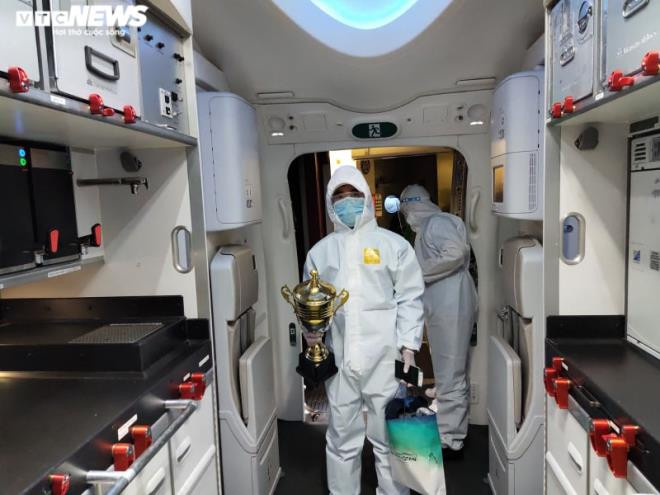 Ngay khi máy bay hạ cánh, 14 trường hợp nhiễm COVID-19 được xác định và 11 thành viên đội Quân y được dự tính sẽ cách ly, điều trị tại Bệnh viện Nhiệt đới Trung ương cơ sở 2 - Đông Anh (ở Hà Nội). Các thành viên còn lại của Đoàn thể thao và 24 lưu học sinh quân sự sẽ cách ly tại Trường Quân sự/Bộ Tư lệnh Thủ đô Hà Nội. Ảnh: Cup vàng của đội tuyển quân sự tham dự Hội thao Army Games 2020 được chuyển lên "siêu" máy bay của Vietnam Airlines.