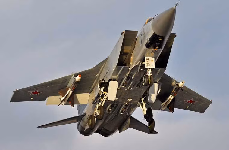 Bánh đáp chiếc MiG-31BM đang được gấp gọn đưa vào khoang chứa bánh khi máy bay rời khỏi mặt đất. Chiếc MiG-31 đang đi làm nhiệm vụ tuần tra không phận với 2 đạn đối không tầm trung R-40.