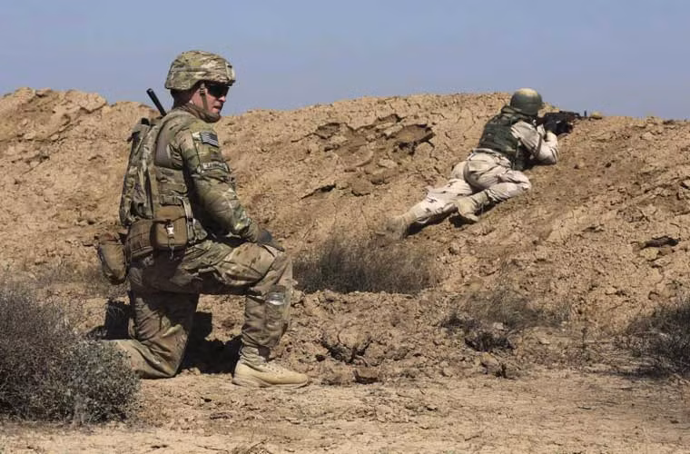 Quan chức quân sự Mỹ nói với AP rằng, một phái đoàn quân sự Mỹ đã được cử tới để hỗ trợ huấn luyện Quân đội Iraq chuẩn bị cho chiến dịch tái chiếm lại Mosul - thành phố lớn thứ 2 của Iraq đang nằm trong tay IS. Có khả năng, chiến dịch này sẽ bắt đầu vào tháng 4 với sự tham gia của 25.000 binh sĩ. Trong ảnh, cố vấn quân sự Mỹ đứng sau chiến hào giúp binh sĩ Iraq phía trước luyện chiến thuật chiến đấu.