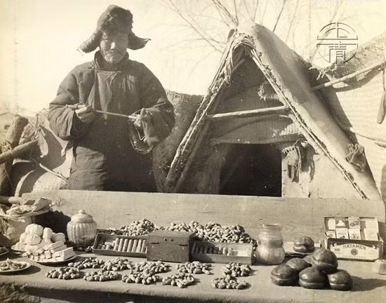 Một người đàn ông và sạp hàng bán thuốc lá, bánh kẹo của mình. Ảnh: sina.com.cn. 