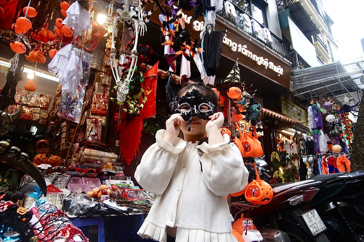 Bé Mai Tường Vi, 5 tuổi ở phố Trần Quang Diệu tỏ ra rất thích thú khi được ông bà cho đi chơi và mua sắm trên phố Hàng Mã. Bé đang đeo thử chiếc mặt nạ với nụ cười rất tươi.