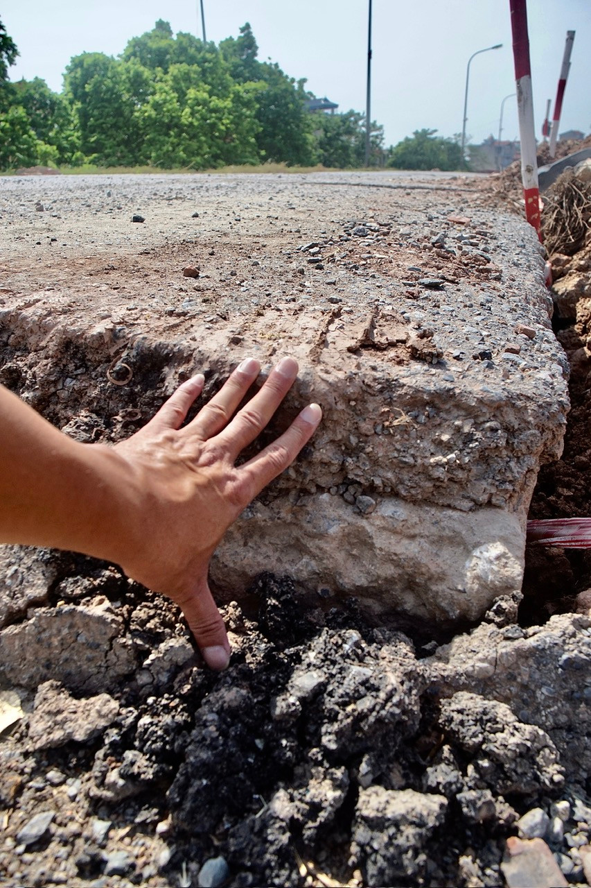 Sụt lún để hở cốt bê tông đường, độ sụt lún bằng một gang tay, khoảng 20cm.